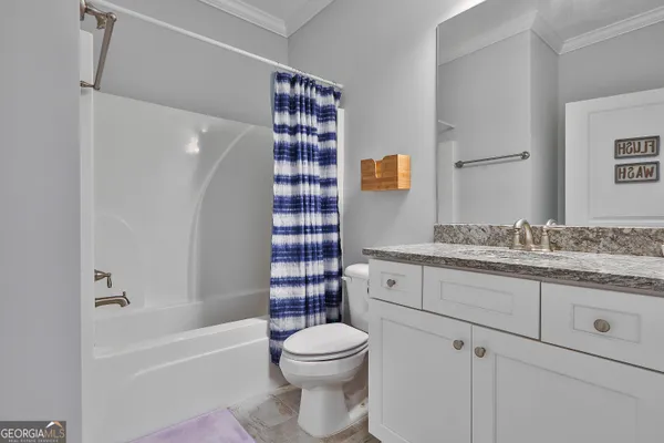a bathroom with a granite countertop toilet sink and mirror