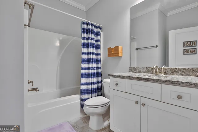 a bathroom with a granite countertop toilet sink and mirror