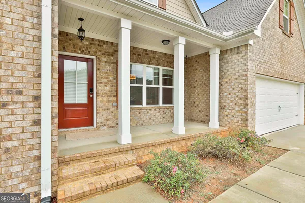 a view of a hallway with wooden floor and furniture