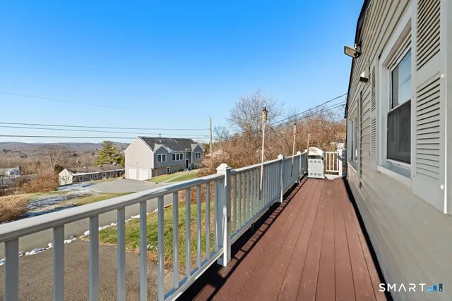 a view of a balcony with wooden floor and fence