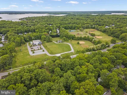 an aerial view of residential houses with outdoor space and trees