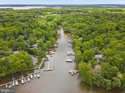 an aerial view of a house with a yard and lake view