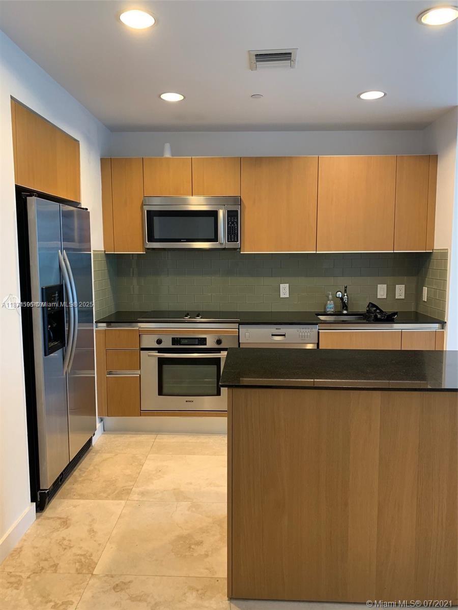 1050 Brickell Avenue, Unit 2808 Miami, FL 33131 - Photo 5 of 10 a kitchen with stainless steel appliances a refrigerator a sink a stove and cabinets