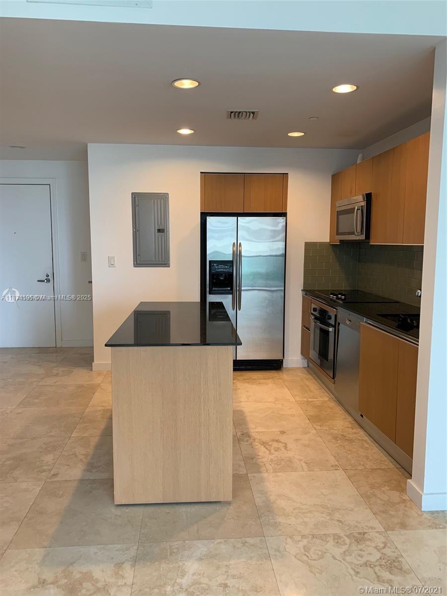 1050 Brickell Avenue, Unit 2808 Miami, FL 33131 - Photo 7 of 10 a large kitchen with stainless steel appliances a large counter top a refrigerator and a stove