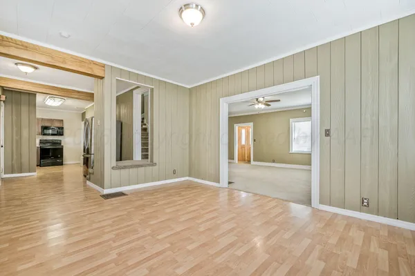 a view of a hallway with wooden floor and a bathroom