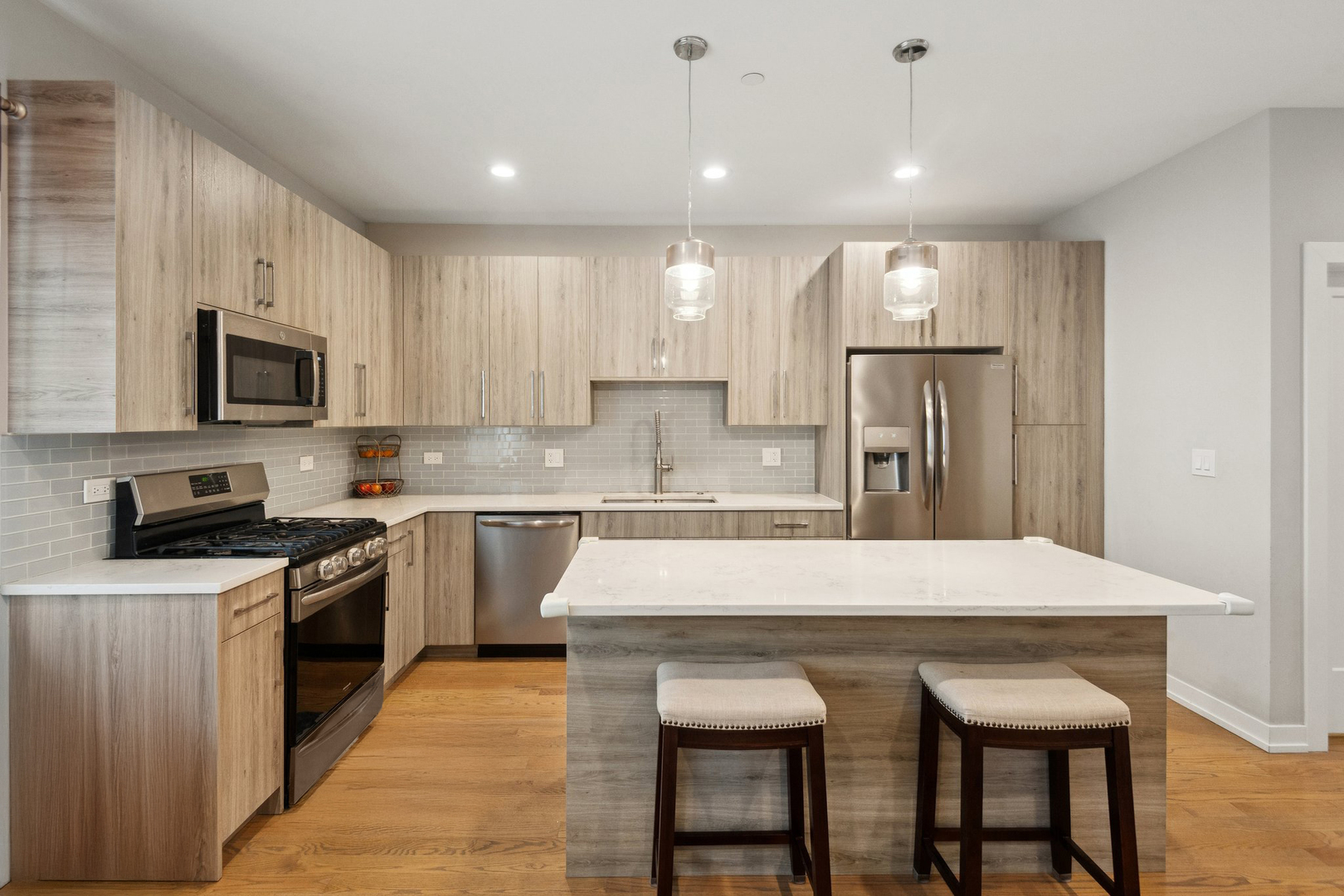 2237 West Coulter Street, Unit 4 Chicago, IL 60608 - Photo 3 of 26 a kitchen with kitchen island a sink table and chairs