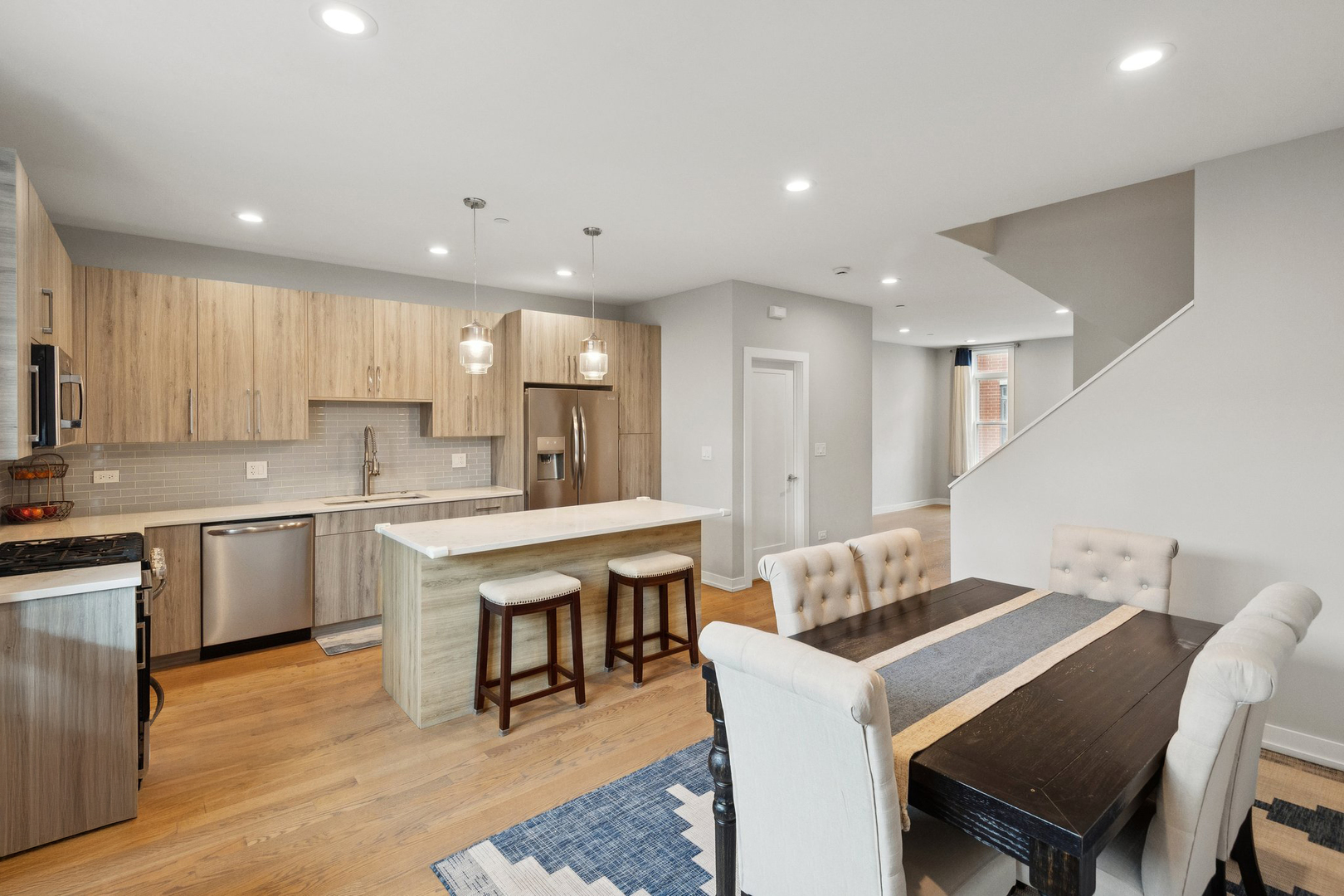 2237 West Coulter Street, Unit 4 Chicago, IL 60608 - Photo 7 of 26 a kitchen with counter space dining table and stainless steel appliances
