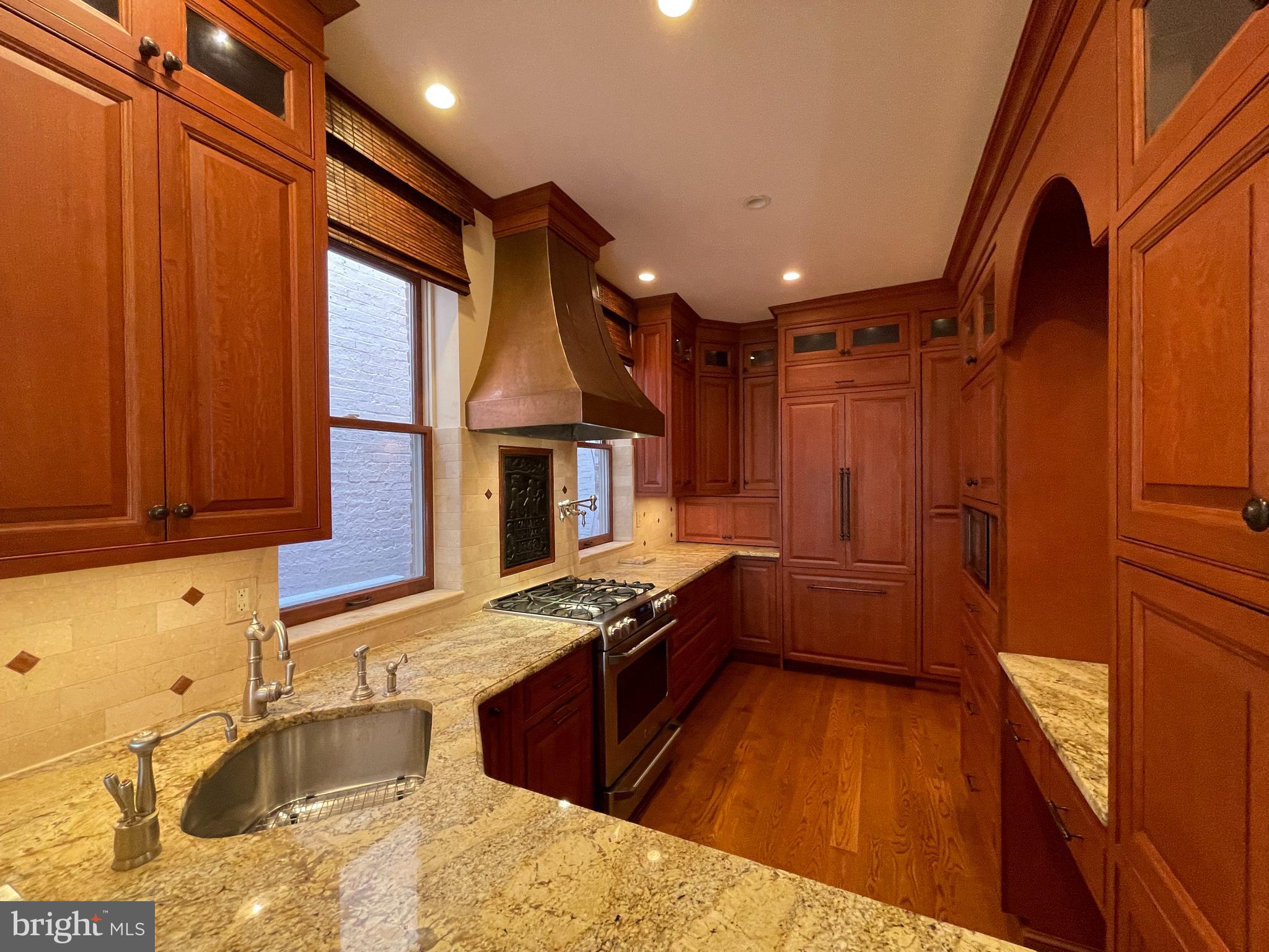 614 A Street Northeast Washington, DC 20002 - Photo 13 of 48 a kitchen with stainless steel appliances granite countertop a sink stove and wooden cabinets