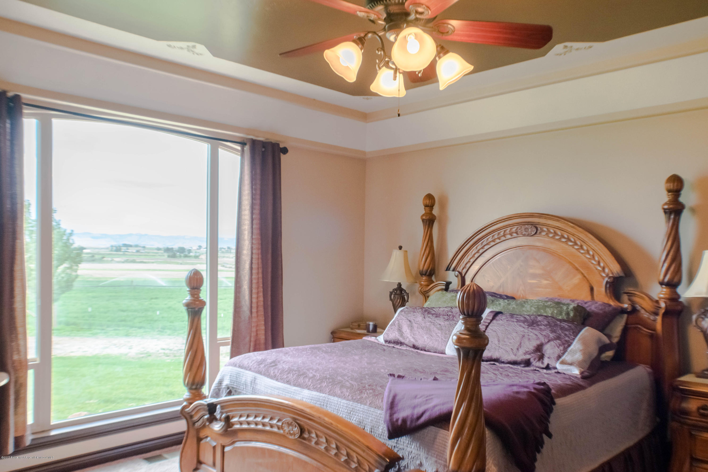 1690 8 Road Mack, CO 81525 - Photo 17 of 37 a bedroom with a bed and a chandelier