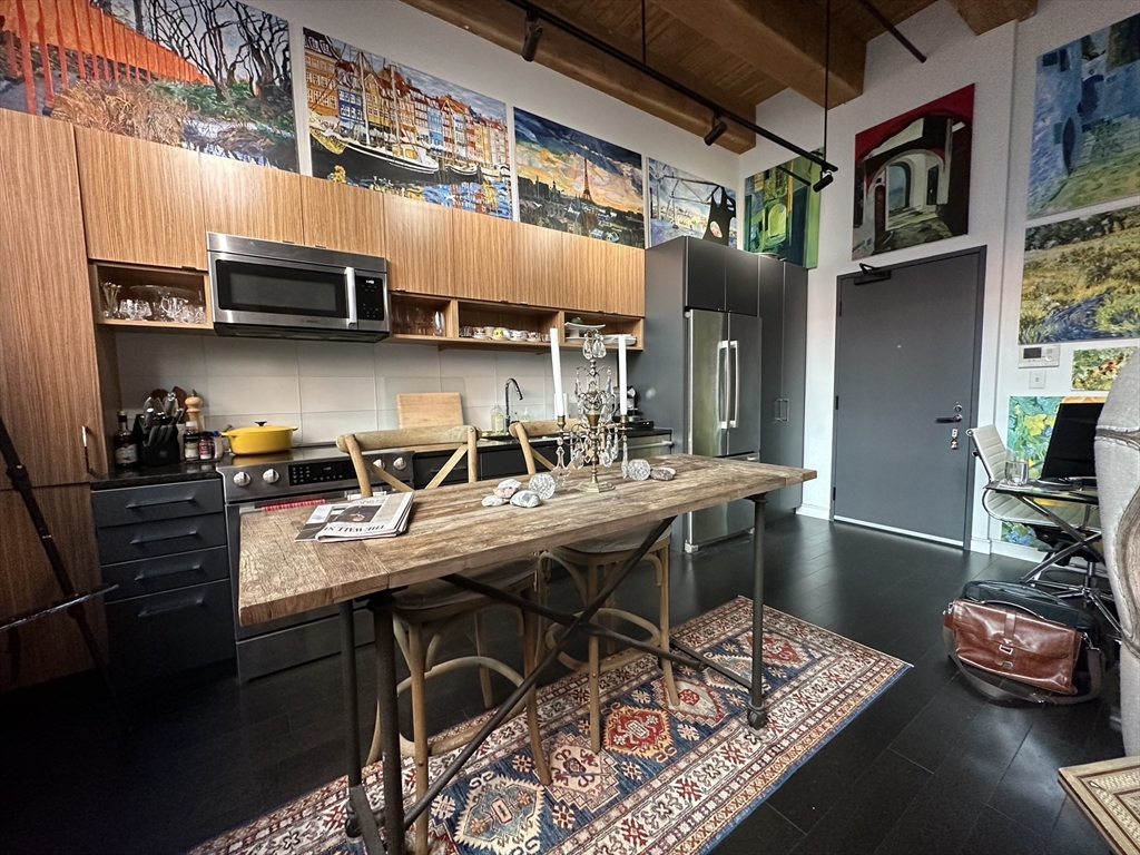 319 A Street, Unit 305 Boston, MA 02210 - Photo 4 of 11 a kitchen with stainless steel appliances granite countertop a sink a stove and a wooden floors