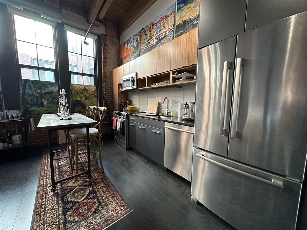 319 A Street, Unit 305 Boston, MA 02210 - Photo 6 of 11 a kitchen with stainless steel appliances a refrigerator a sink a stove and cabinets