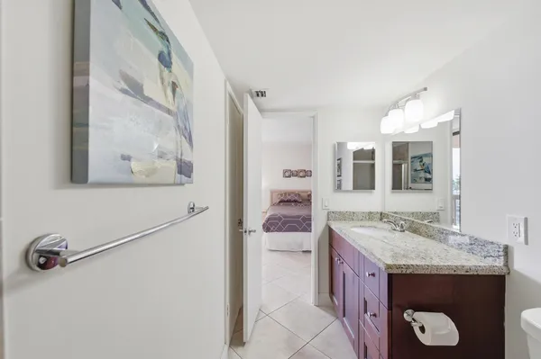 a bathroom with a granite countertop sink and a mirror