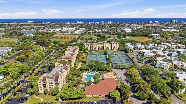 an aerial view of residential houses with outdoor space and trees