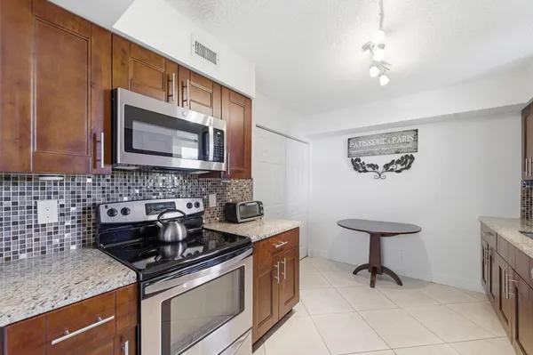 a kitchen with stainless steel appliances granite countertop a sink stove and microwave