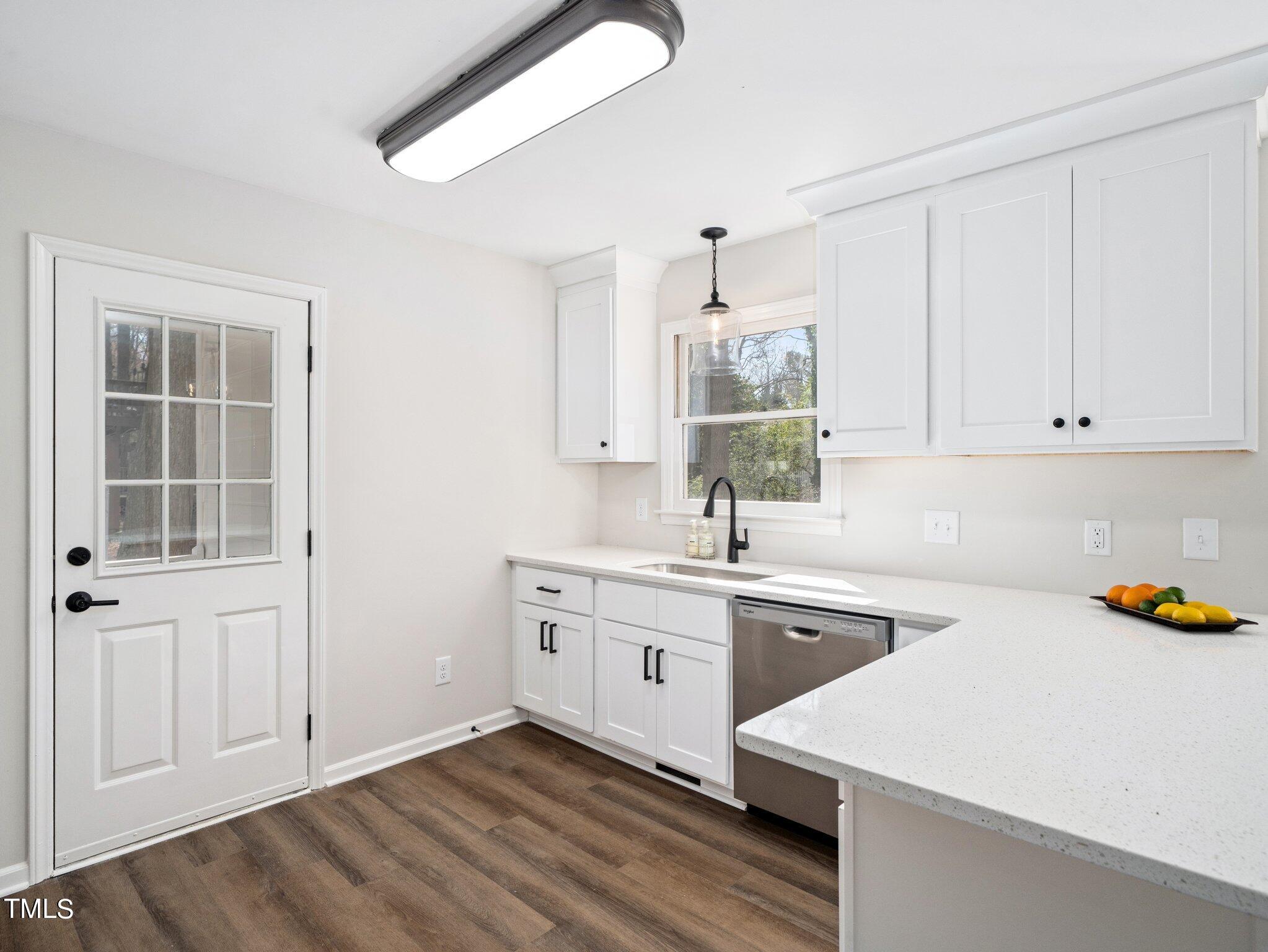 3512 Donna Road Raleigh, NC 27604 - Photo 12 of 28 a kitchen with a sink dishwasher and cabinets with wooden floor