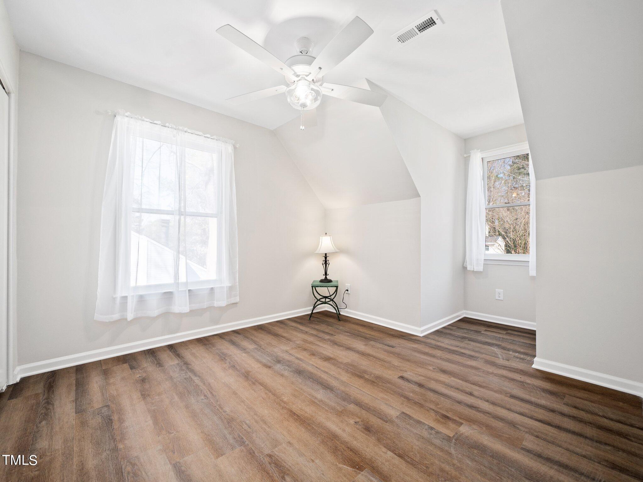 3512 Donna Road Raleigh, NC 27604 - Photo 18 of 28 an empty room with wooden floor chandelier fan and windows