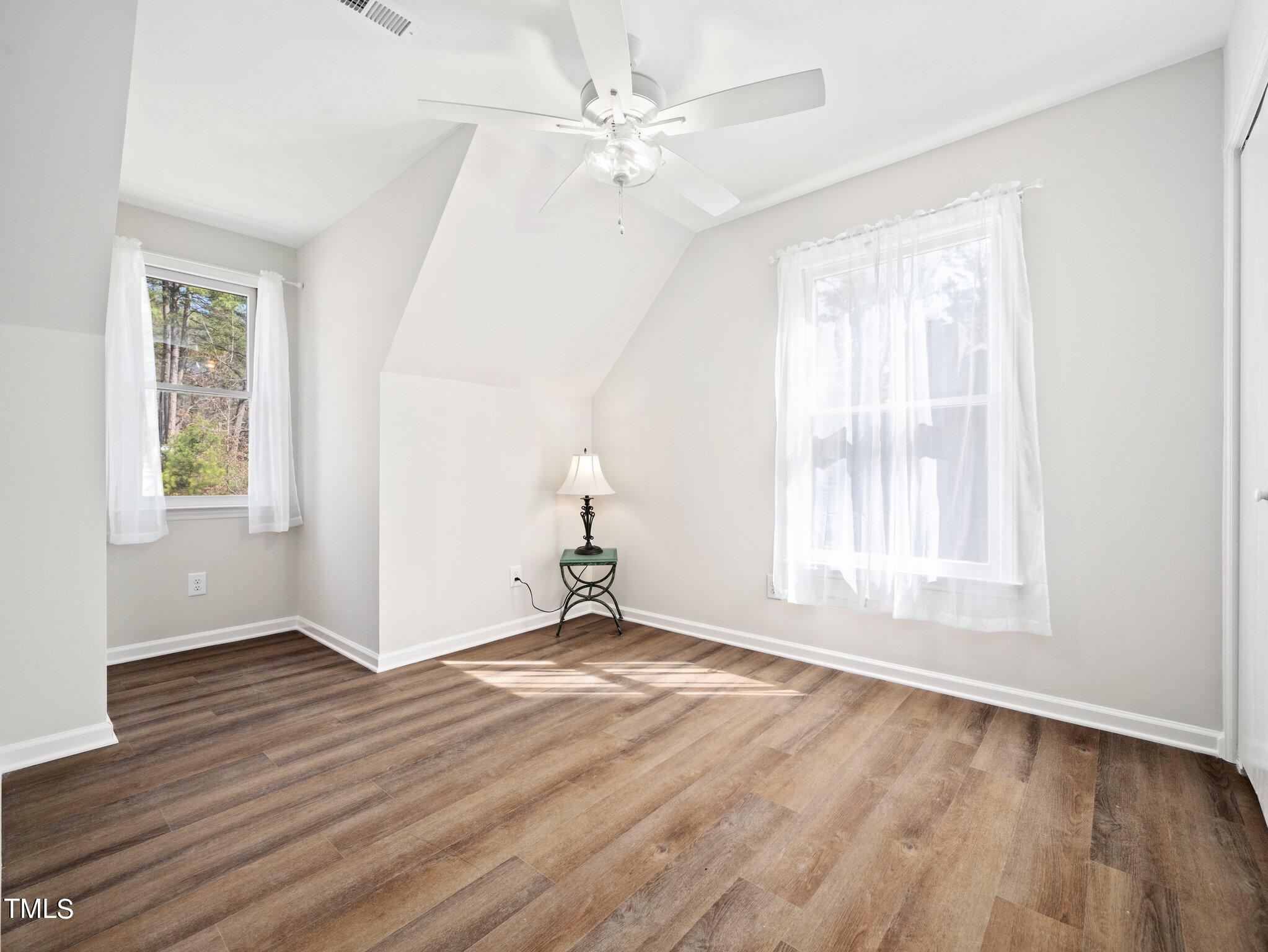 3512 Donna Road Raleigh, NC 27604 - Photo 19 of 28 an empty room with wooden floor chandelier fan and windows