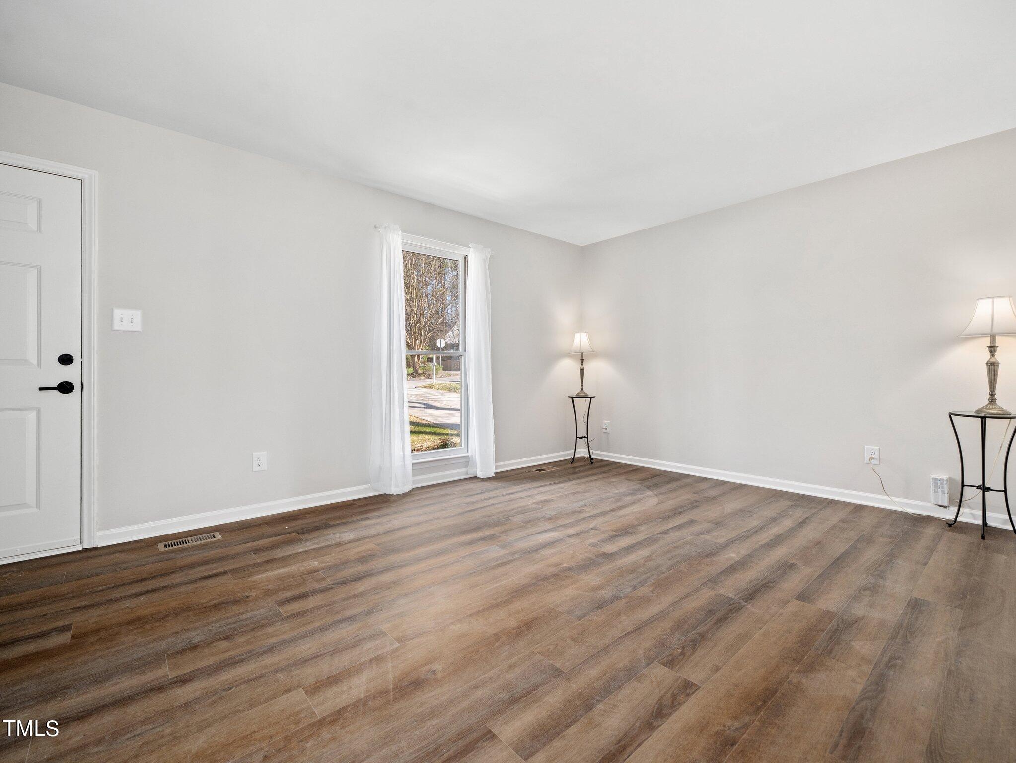 3512 Donna Road Raleigh, NC 27604 - Photo 7 of 28 a view of an empty room with wooden floor and a window