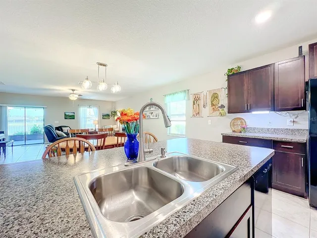 a kitchen with stainless steel appliances kitchen island granite countertop a refrigerator and a stove top oven