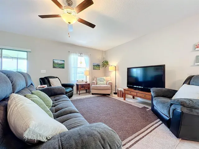a living room with furniture and a view of kitchen