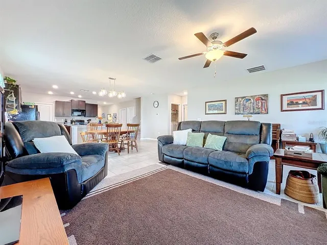 a living room with furniture and a floor to ceiling window