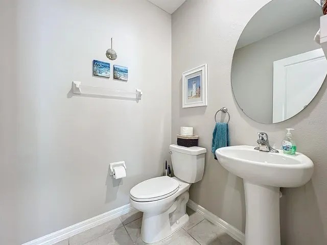 a spacious bathroom with a granite countertop sink a toilet a mirror and