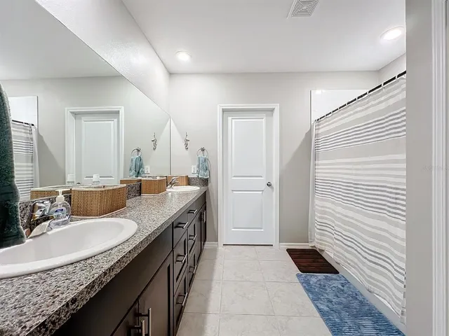 a view of an empty room with window and chandelier fan