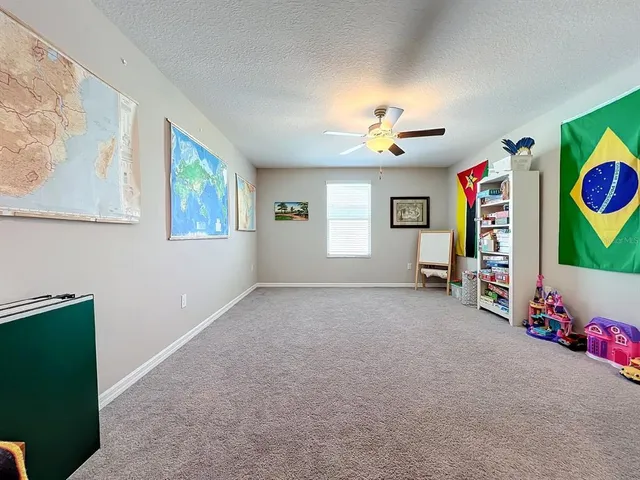 a spacious bedroom with a bed and a ceiling fan