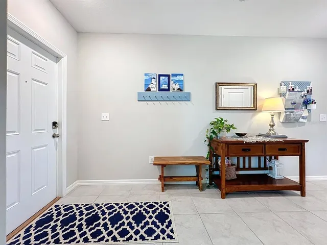 a living room with furniture a piano and a bookshelf