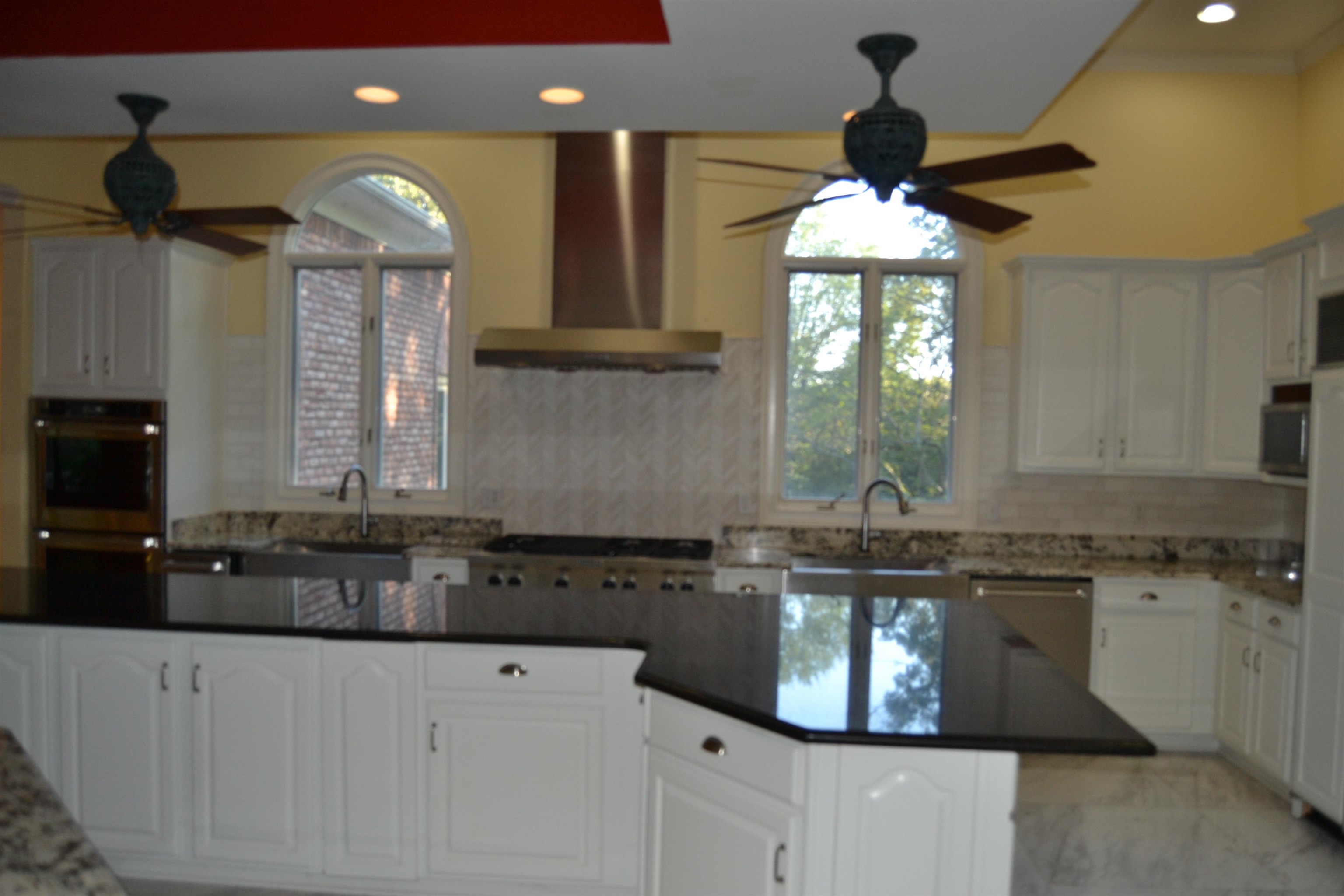 470 Walnut Point Cove Memphis, TN 38018 - Photo 13 of 37 Kitchen with ceiling fan, white cabinets, wall chimney range hood, and recessed lighting