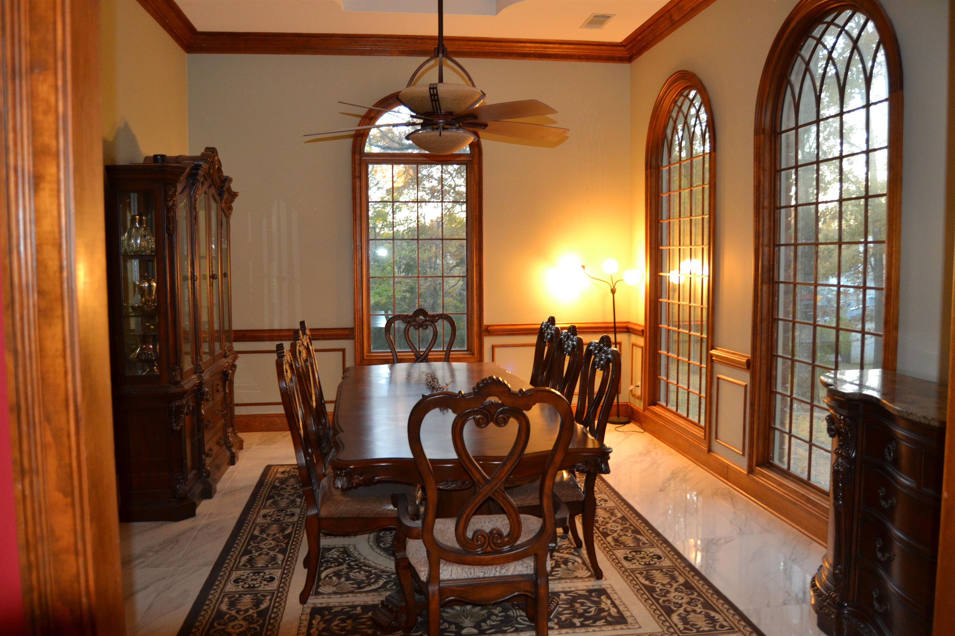 470 Walnut Point Cove Memphis, TN 38018 - Photo 4 of 37 Dining room with ornamental molding, light marble finish flooring, a wainscoted wall, ceiling fan, and a decorative wall