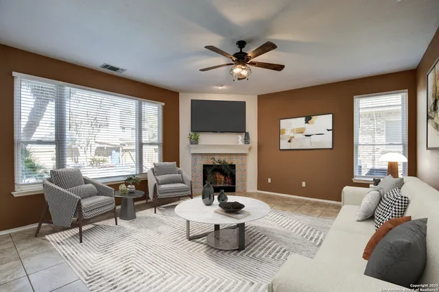 a living room with furniture a fireplace and a large window