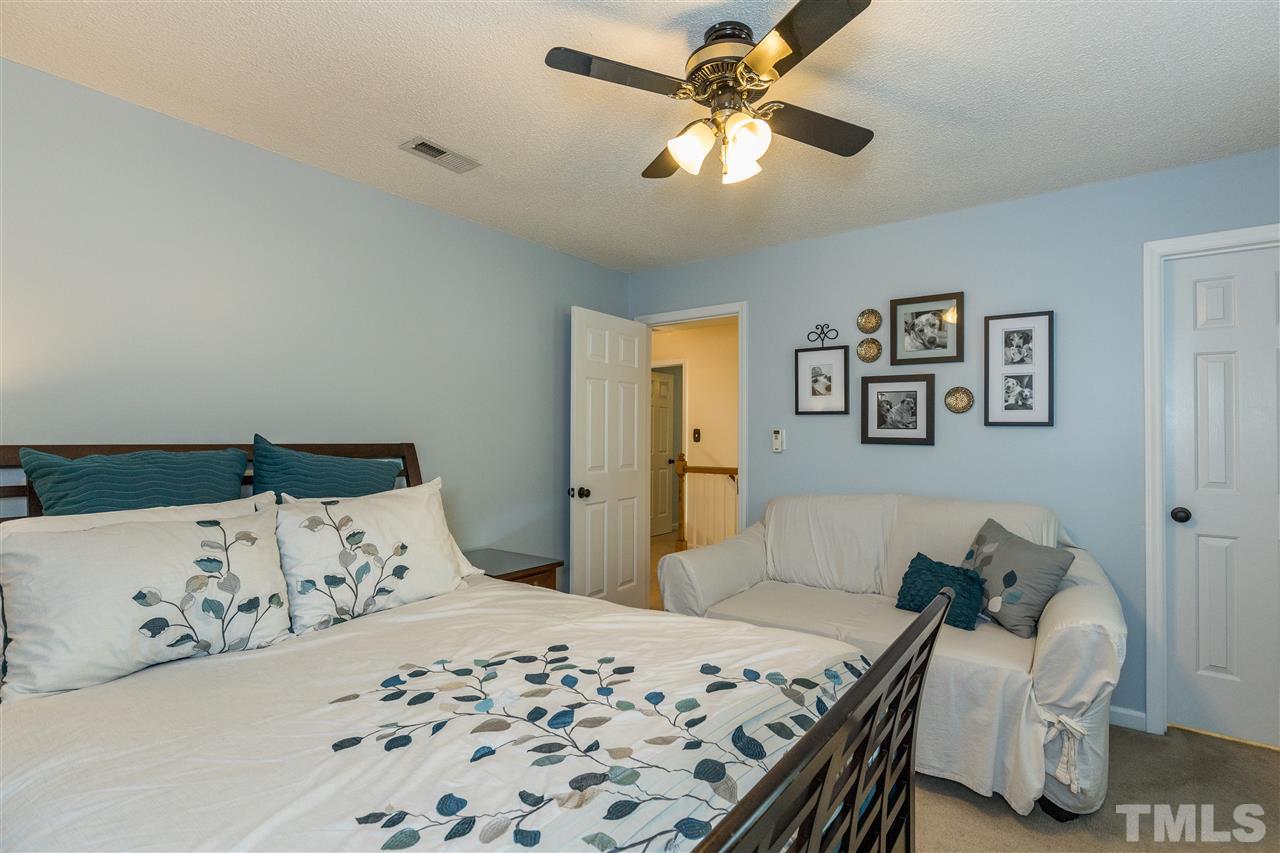 6004 Dedmon Place Raleigh, NC 27616 - Photo 23 of 30 a bedroom with a bed and a chandelier