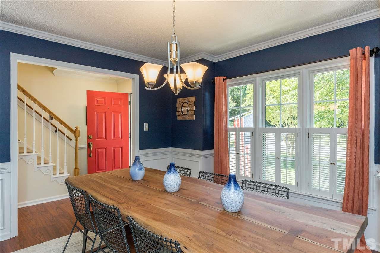 6004 Dedmon Place Raleigh, NC 27616 - Photo 5 of 30 a dining room with wooden floor a chandelier a glass table and chairs