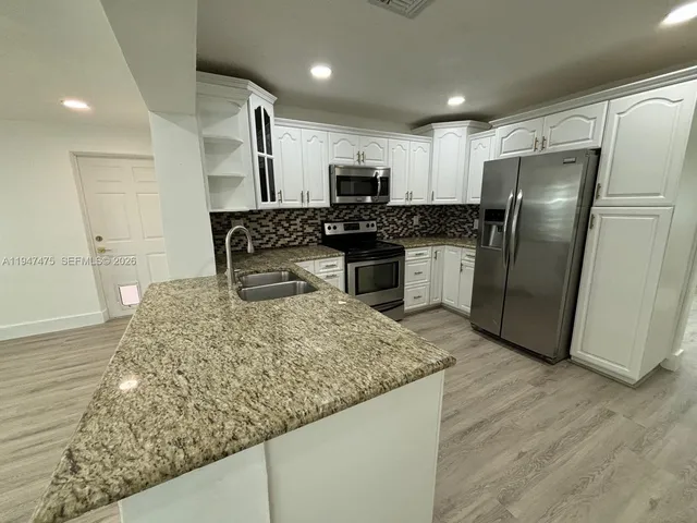 a front view of a house with a yard and trees