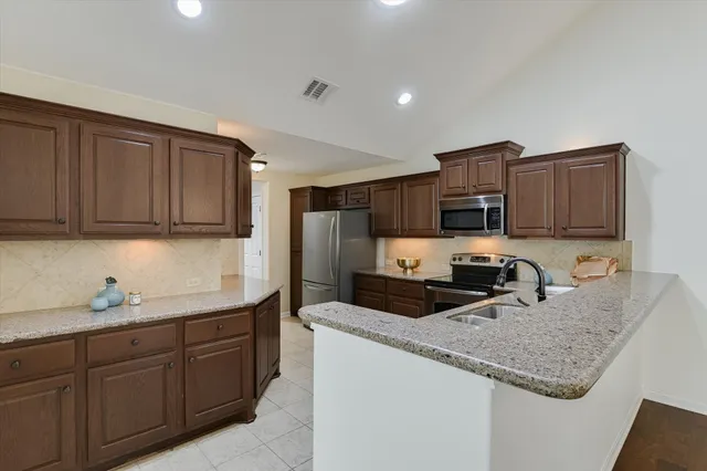 a kitchen with sink a microwave and cabinets