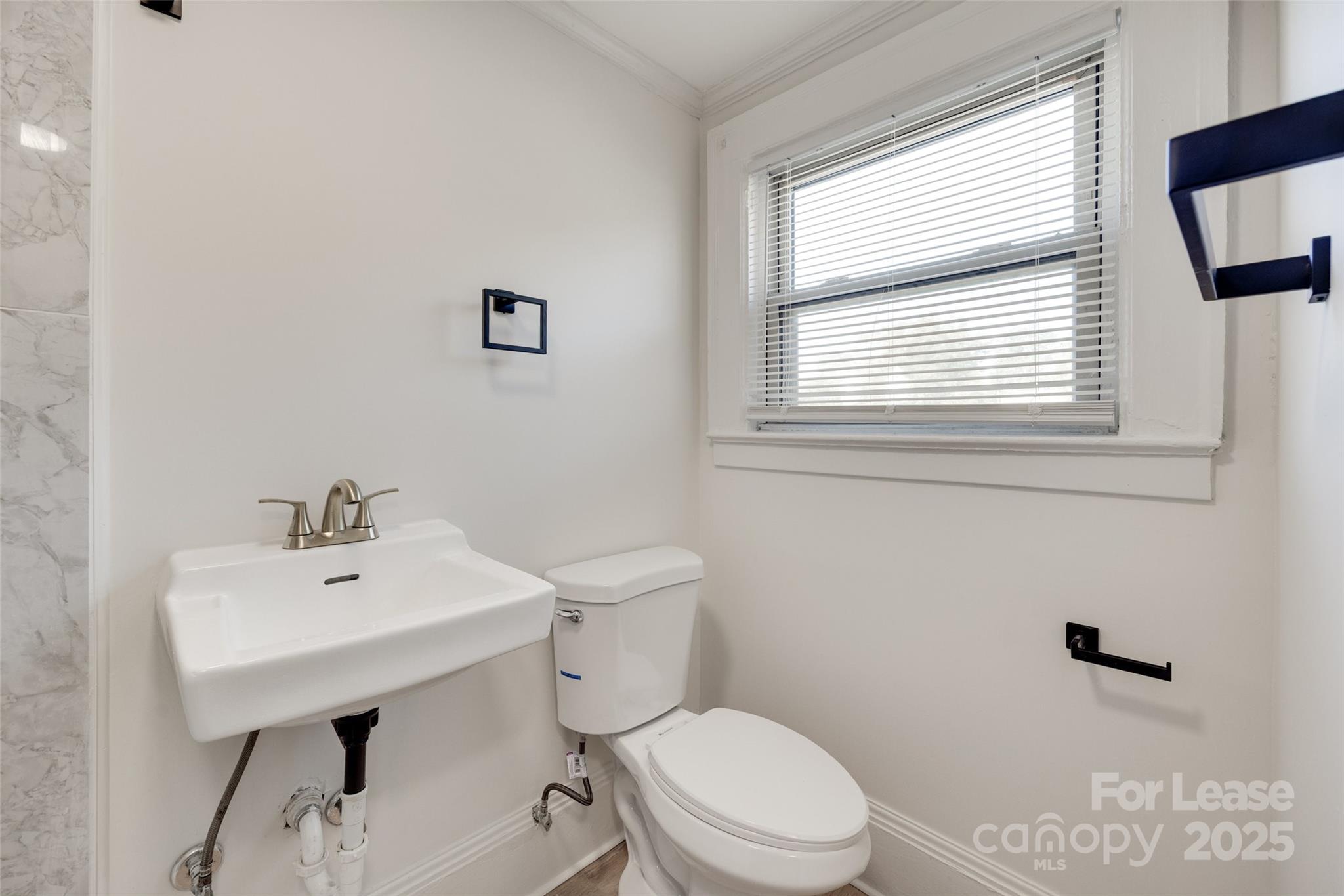 49 Corban Avenue Southwest, Unit 3 Concord, NC 28025 - Photo 15 of 16 a bathroom with a sink a mirror and a toilet