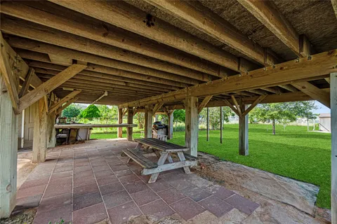 a view of a backyard with table and chairs under a large umbrella