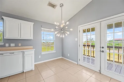 a view of an empty room with window and cabinet area