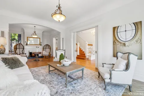 a living room with furniture a chandelier and a table