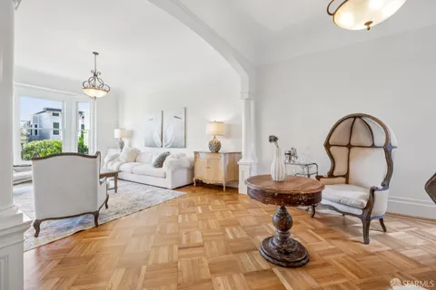 a living room with furniture a fireplace and a large window