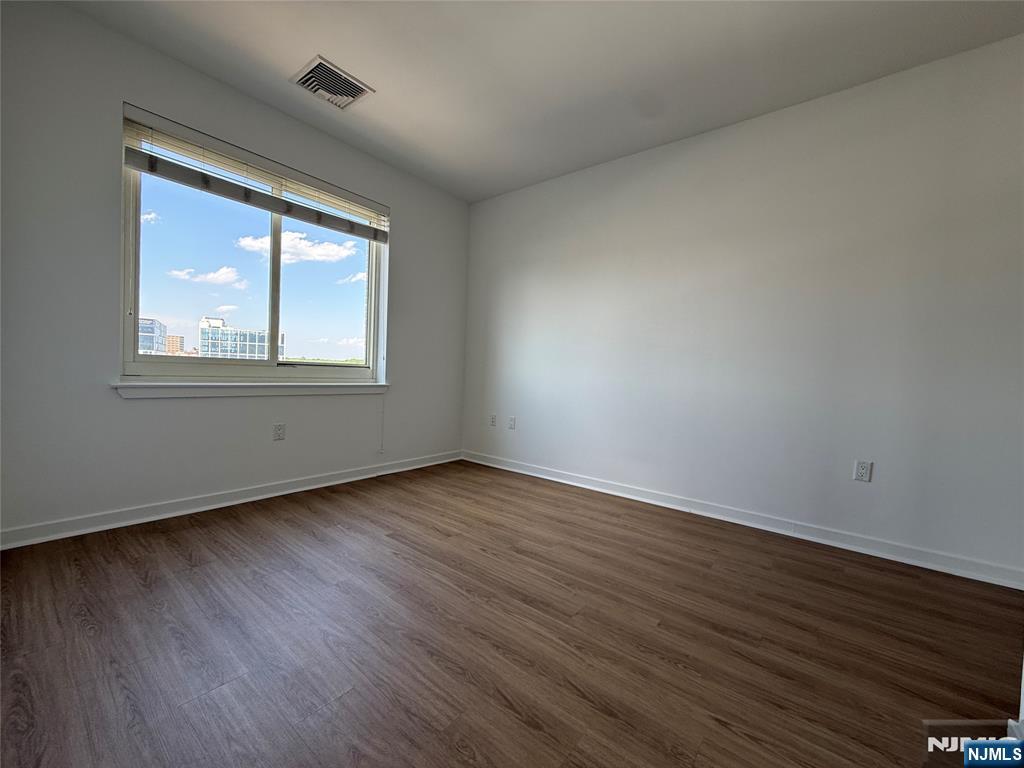 2050 North Central Road, Unit 710 Fort Lee, NJ 07024 - Photo 6 of 21 an empty room with wooden floor and windows