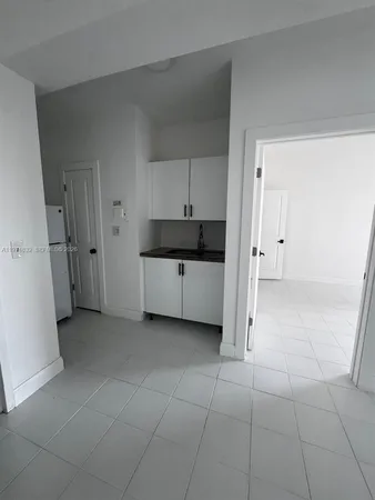 a view of a kitchen with dishwasher and white cabinets