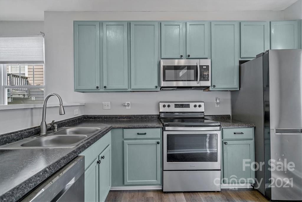 6323 Gammon Road Charlotte, NC 28269 - Photo 3 of 28 a kitchen with granite countertop a stove sink and refrigerator