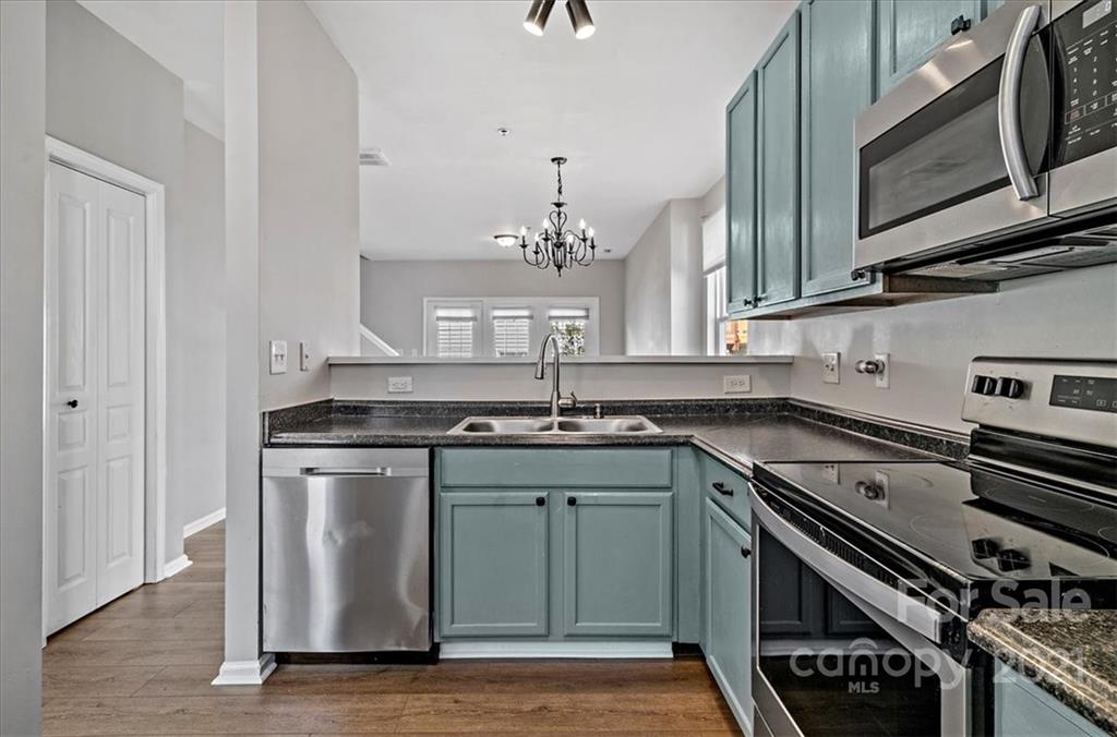 6323 Gammon Road Charlotte, NC 28269 - Photo 5 of 28 a kitchen with stainless steel appliances granite countertop a sink stove and microwave