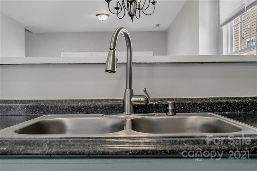 6323 Gammon Road Charlotte, NC 28269 - Photo 7 of 28 a kitchen with a sink a faucet and cabinets