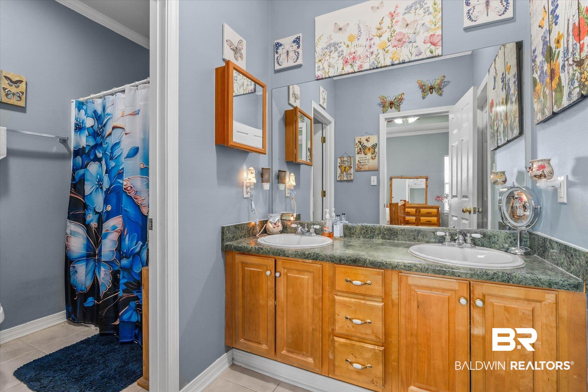 22095 Buck Road Robertsdale, AL 36567 - Photo 12 of 22 Bathroom with double vanity, ornamental molding, curtained shower, and light tile patterned floors