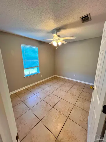 an empty room with windows and fan