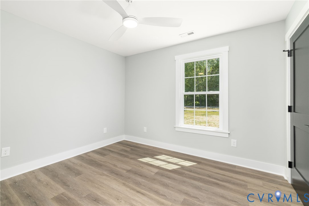 2085 Skippers Road Emporia, VA 23847 - Photo 15 of 34 an empty room with wooden floor and windows