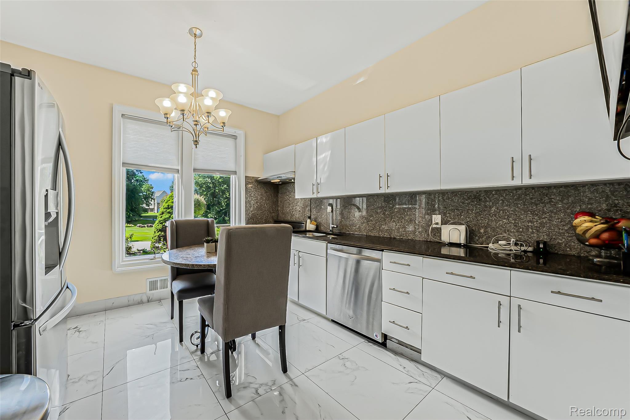 2785 Cranbrook Ridge Court Rochester, MI 48306 - Photo 53 of 99 Kitchen featuring white high-gloss cabinetry, dark stone countertops, stainless steel appliances, and large format tile flooring